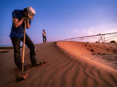 A center pivot irrigation system buried in sand.