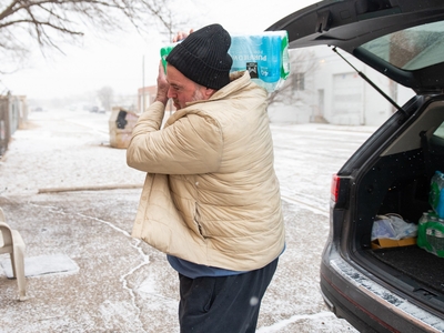 Tony Foster, a volunteer at the Code Blue Warming Station in Amarillo, brought in cases of bottled water to the shelter on Friday.