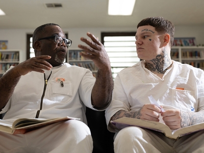 Freeman Arthur Brown, left, and Carroll Trent Dodson talk as they read through GED prep books in the library at the Wynne Unit in Huntsville.
