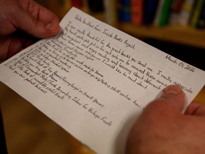 A volunteer with Inside Project Books reads a letter from an incarcerated person following a TDJC ban on hardcover books over fears that they could be used to ferry in contraband.