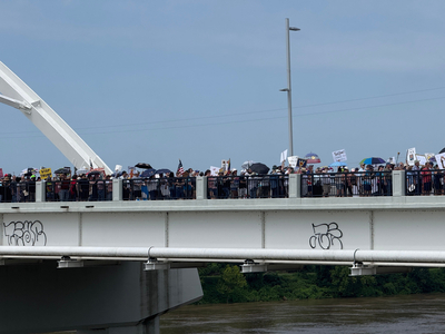 Protesters march across Little Rock's Veteran's Memorial Bridge on Saturday, June 14, 2025, as part of a national "No Kings" demonstration against Trump administration policies and actions.