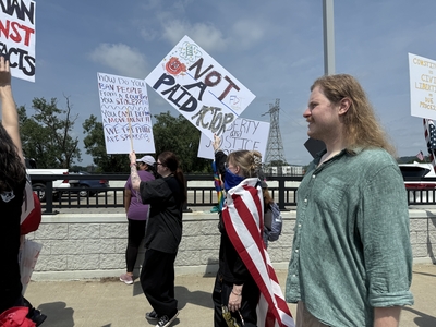 A protester marches across Veterans Memorial Bridge in Little Rock as part of the No Kings protest on June 14, 2025.