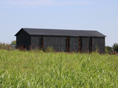 The black tobacco barn seen from the outside.