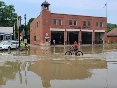 Child bikes through flooded street