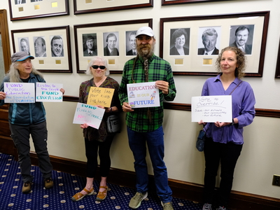 Demonstrators with signs show support for public education in the hallway of the Alaska State Capitol, ahead of the legislative special session on Aug. 2, 2025 (Photo by Corinne Smith/Alaska Beacon)