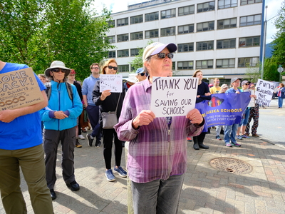 A demonstrator holds a sign at the Alaska State Capitol on Aug 2, 2025 (Photo by Corinne Smith/Alaska Beacon)