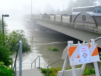Flood waters of the Mendenhall River seen rushing below the Brotherhood Bridge about an hour after the peak flood levels at 8:30 a.m. on Aug 13, 2025 (Photo by Corinne Smith/Alaska Beacon)