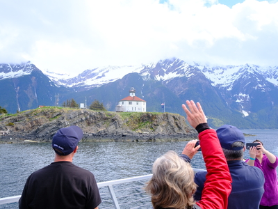 Supporters wave goodbye to volunteers at the Eldred Rock Lighthouse before departing after the grand opening ceremony on May 30, 2026. (Photo by Corinne Smith/Alaska Beacon)