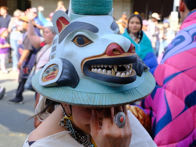 A dancer with the Chilkat Thunderbird & Sockeye Clans dance group shows off a Tlingit white bear hat belonging to the Shangukeidí Thunderbird clan during the procession to the Grand Entrance, part of the opening of Celebration in Juneau on June 3, 2026. (Photo by Corinne Smith/Alaska Beacon)