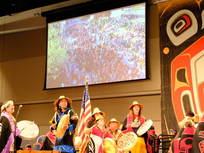 Members of the Lepquinm Gumilgit Gagoadim Tsimshian (Our Own Dance in Our Hearts) dance group led the Grand Entrance of Celebration with singing and drumming on stage at Juneau's Centennial Hall on June 3, 2026. (Photo by Corinne Smith/Alaska Beacon)