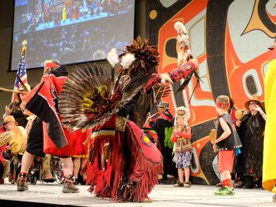 Thomas Yellowhorse Davis who is Oglala Lakota and Tlingit from Hoonah, and dancing with the Mt. Fairweather dance group from Hoonah on the main stage of Centennial Hall during the Grand Entrance of Celebration on June 3, 2026. (Photo by Corinne Smith/Alaska Beacon)