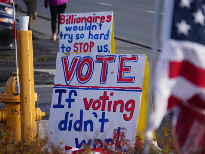 Signs set up on Northern Lights Boulevard in Midtown Anchorage on Oct. 19, 2026, carry a message about the importance of voting, a theme of the No Kings protest events. (Photo by Yereth Rosen/Alaska Beacon)