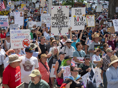 Mac Farish holds a sign that reads "we the people outnumber your cabinet 16,513,850 to 1" among a sea of other signs during the June 14, 2025, "No Kings" rally at the Statehouse.