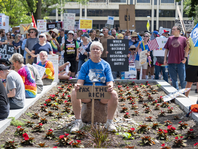 Lee Boyd, of Lawrence, holds a sign that reads "Tax the rich" at the June 14, 2025, "No Kings" rally in Topeka.