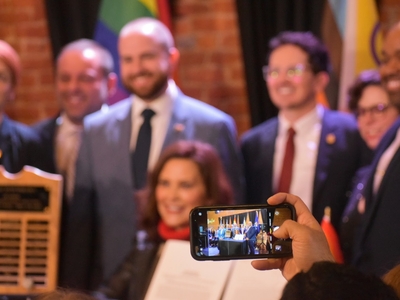 Whitmer signs LGBTQ+ non-discrimination bill into law alongside civil rights pioneer Mel Larsen