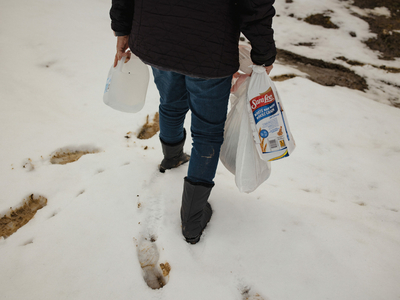 Bercy Martinez carries groceries and water for her brother