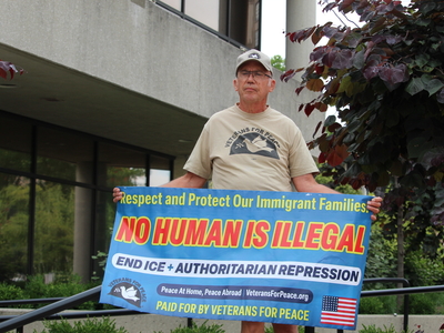 A man holds up a sign at a rally for Haitians in Springfield, Ohio on June 25, 2026. (Photo by Megan Henry, Ohio Capital Journal).