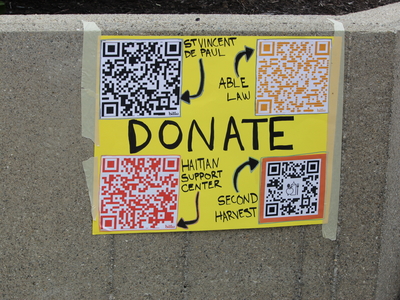 A sign urging people to donate at a rally for Haitians in Springfield, Ohio on June 25, 2026. (Photo by Megan Henry, Ohio Capital Journal).