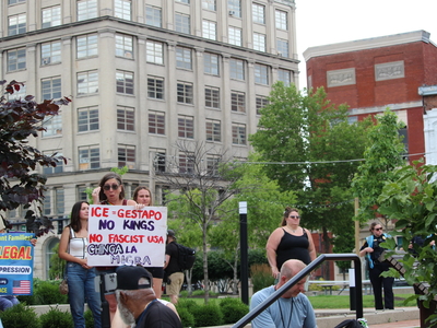 A woman holds up a sign at a rally for Haitians in Springfield, Ohio on June 25, 2026. (Photo by Megan Henry, Ohio Capital Journal).