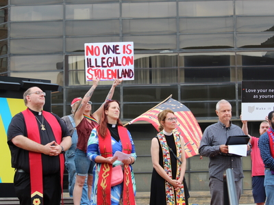 A woman holds up a sign at a rally for Haitians in Springfield, Ohio on June 25, 2026. (Photo by Megan Henry, Ohio Capital Journal).