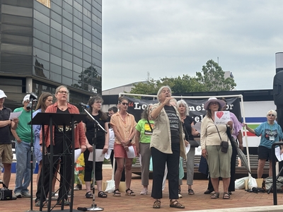 The World House Choir from Yellow Springs, Ohio leads people in song at a rally for Haitians in Springfield, Ohio on June 25, 2026. (Photo by Megan Henry, Ohio Capital Journal).