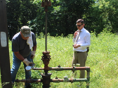 Bob Wilson, an oil producer in Washington County (left) reads the pressure of an injection well in Marietta while Ohio state Rep. Tristan Rader, D-Lakewood watches. (Photo by Megan Henry, Ohio Capital Journal).