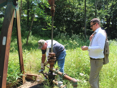 Bob Wilson, an oil producer in Washington County (left) reads the pressure of an injection well in Marietta while Ohio state Rep. Tristan Rader, D-Lakewood looks on. (Photo by Megan Henry, Ohio Capital Journal).