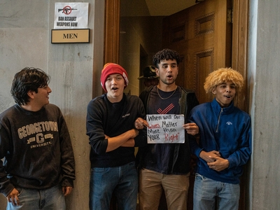 Three teenage boys with locked arms stand in front of the men's room outside the Tennessee House of Representatives chamber. (Photo: John Partipilo)