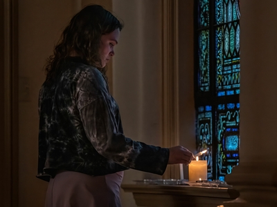 Lane Parker lights a candle for victims of the Covenant School shooting at Belmont United Methodist Church. (Photo: John Partipilo)