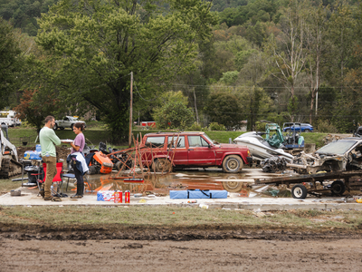 Supplies, including bottled water, contrast with wrecked vehicles in standing water. (Photo: Brandon Hull/Office of the Governor)