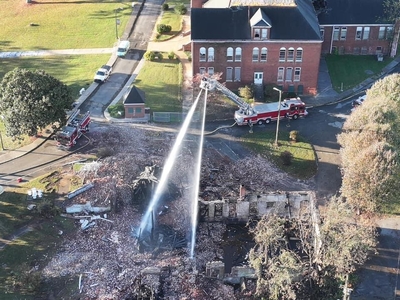 Fire trucks water the smoldering ashes of Elnathan Hall on the campus of Knoxville College in Knoxville, Tennessee. (Photo: Knox County Fire Department)