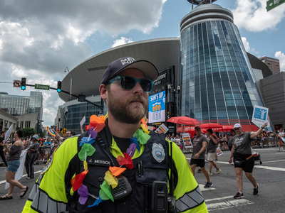 Metro Nashville Police officer J. Messick,decorated with a flower garland while he stood duty at the Nashville Pride Parade. (Photo: John Partipilo/Tennessee Lookout)