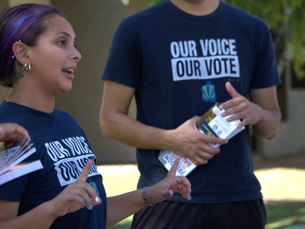Claudia Kline, an organizer for Our Voice, Our Vote Arizona, speaks to a group of canvassers before they set out to knock on doors in 106-degree weather in Phoenix on Thursday, Sept. 26. The organization is part of a coalition that vowed to knock on 3 million doors by November. (Gloria Rebecca Gomez / Arizona Mirror)