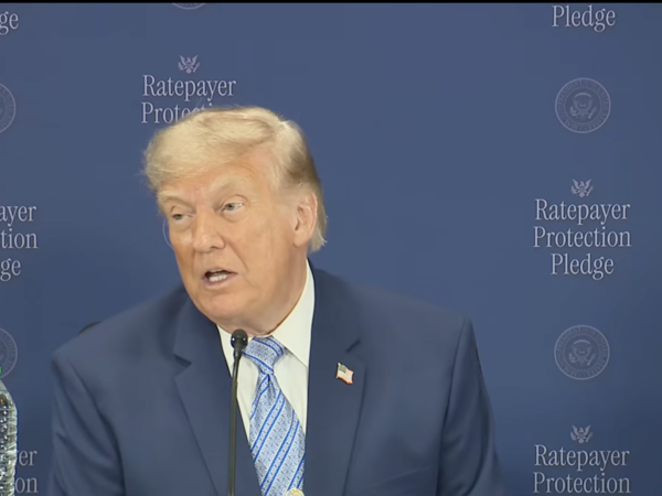 Trump speaks in front of blue background that says "Ratepayer Protection Pledge"