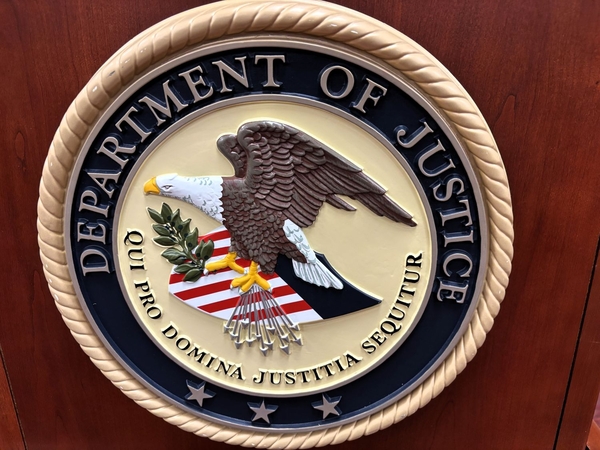 The U.S. Department of Justice logo is displayed on a speaker’s podium at the federal courthouse in Rapid City, South Dakota, on July 21, 2026. (Photo by Seth Tupper/South Dakota Searchlight)