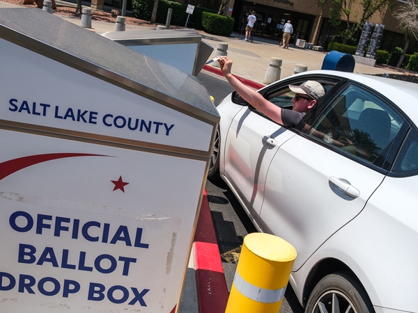 A voter drops off a ballot on primary Election Day at the Salt Lake County Government Center on Tuesday, June 23, 2026. (Photo by Marco Lozzi for Utah News Dispatch)