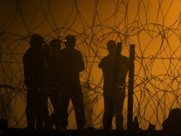 Migrants wait through the night on May 10, 2023, in a dust storm, on land between the Rio Grande and the U.S.-Mexico border wall, hoping they will be processed by immigration authorities before the expiration of Title 42, a public health order used to expel migrants. (Photo by Corrie Boudreaux/Source NM)