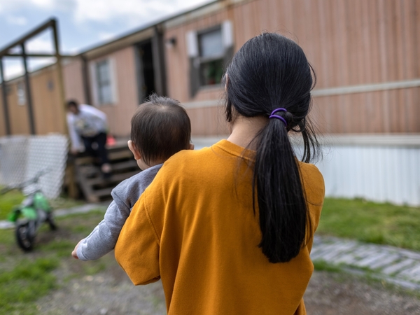 A 10-year-old Honduran immigrant who came into the United States as an unaccompanied minor carries her baby cousin on April 25, 2021, after reuniting with extended family in Sellersburg, Indiana. (Photo by John Moore/Getty Images)
