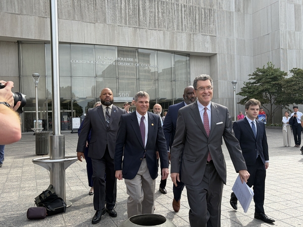 Olympian David Hearn, center left, walks out of District of Columbia Superior Court with his attorneys after a hearing on Sept. 4, 2026. (Photo by Ariana Figueora/States Newsroom)