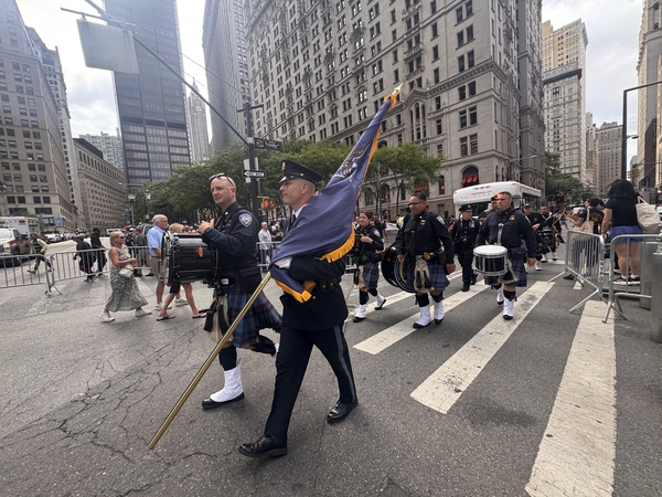 NYPD officers walk down a street in downtown Manhattan as part of the 25th anniversary of 9/11 memorial on Sept. 11, 2026. (Photo by Shalina Chatlani/ Stateline)