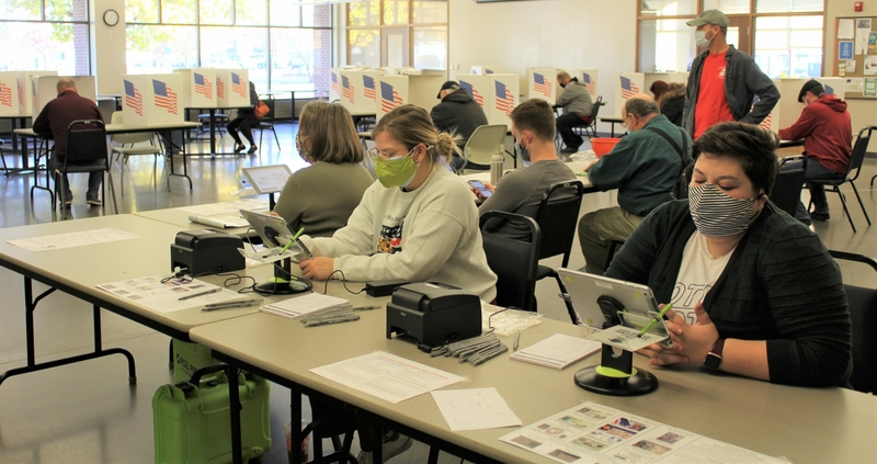 Poll workers assist voters at the Westside Community Center in West Des Moines' Valley Junction neighborhood shortly after 8 a.m. on Nov. 3, 2020. (Photo by Perry Beeman/Iowa Capital Dispatch)