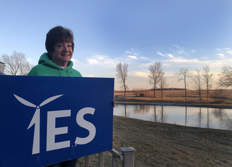 Anne Fry, who had signed a lease to part of her land in Seneca County, Ohio, with a wind energy company, stands with a sign supporting wind development outside her house in February of 2023. (Robert Zullo/ States Newsroom)