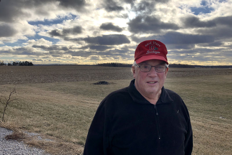 Dave Crum, 78, stands in front of his farmland in Crawford County, Ohio. Crum had signed a lease to be part of the Honey Creek wind project, which was thwarted by a county vote in 2022 for a 10-year moratorium on wind projects and overwhelming rejected later that year by a local voter ballot measure. (Robert Zullo/ States Newsroom)