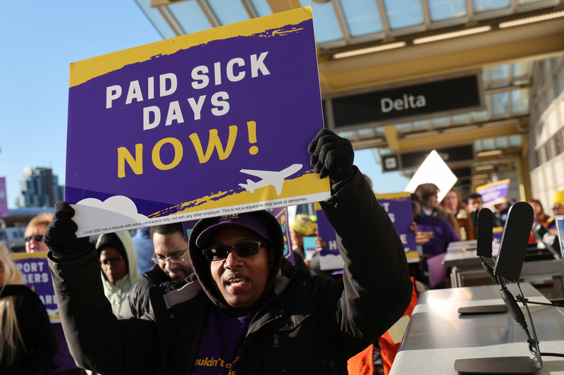 Airport workers and supporters march during a rally at Ronald Reagan Washington National Airport on March 7, 2023 in Arlington, Virginia. The group, organized by the Service Employees International Union, is demanding Metropolitan Washington Airports Authority mandate paid sick leave and employer-paid health care for airport service workers at Washington National and Dulles International Airport. Virginia law does not require employers to provide paid sick leave. (Photo by Kevin Dietsch/Getty Images)