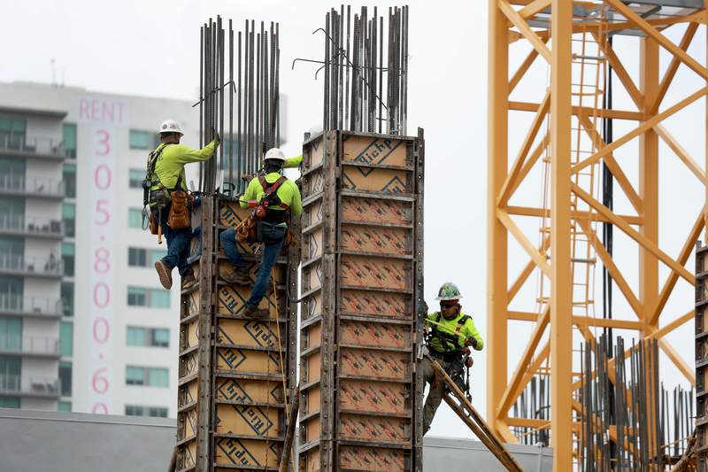 Construction workers build a residential high rise on Oct. 2, 2023, in Miami. Inflation is slowing and job growth has surged, but housing costs are still high, partly because of high demand, low inventory and mortgage rates. (Photo by Joe Raedle/Getty Images)