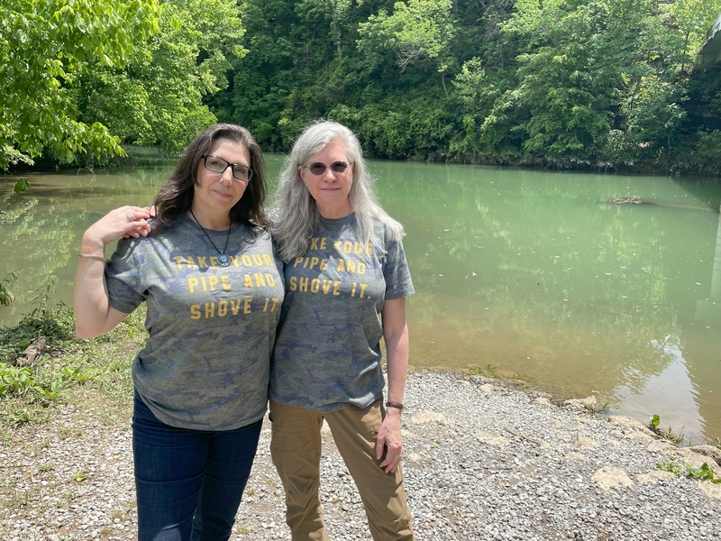 Tracy O'Neill, left, and Nanette Mahler, pose near Sycamore Creek in Cheatham County, Tenn. O'Neill and Mahler live near the site of a proposed Tennessee Valley Authority gas-fired power plant project, which also would include a battery storage facility, pipeline and transmission infrastructure. They are helping lead the local fight against the project and worry about harm to water quality. (By Robert Zullo/ States Newsroom)