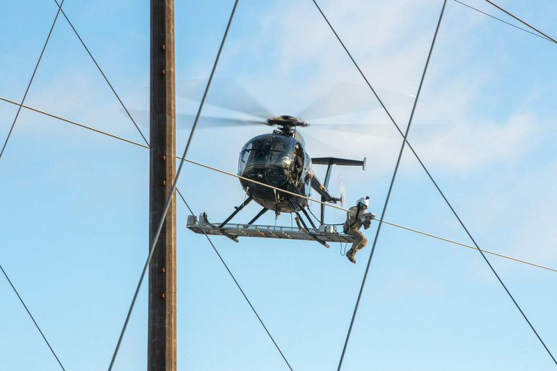 A PPL Electric Utilities employee installs a dynamic line rating sensor onto a transmission line in Pennsylvania from a helicopter. The system was installed in 2022. The sensors allow utilities to take into account wind speed, cloud cover and other conditions to determine if a line has more capacity. (Courtesy of PPL Electric Utilities)
