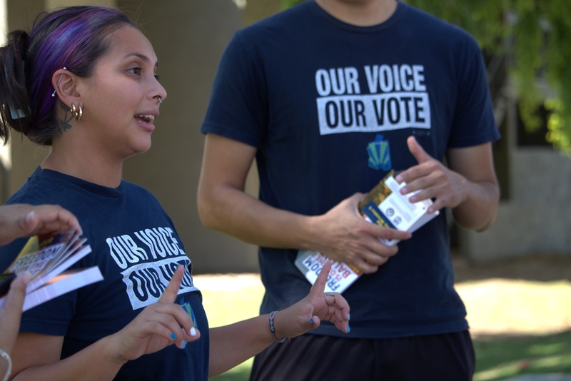 Claudia Kline, an organizer for Our Voice, Our Vote Arizona, speaks to a group of canvassers before they set out to knock on doors in 106-degree weather in Phoenix on Thursday, Sept. 26. The organization is part of a coalition that vowed to knock on 3 million doors by November. (Gloria Rebecca Gomez / Arizona Mirror)