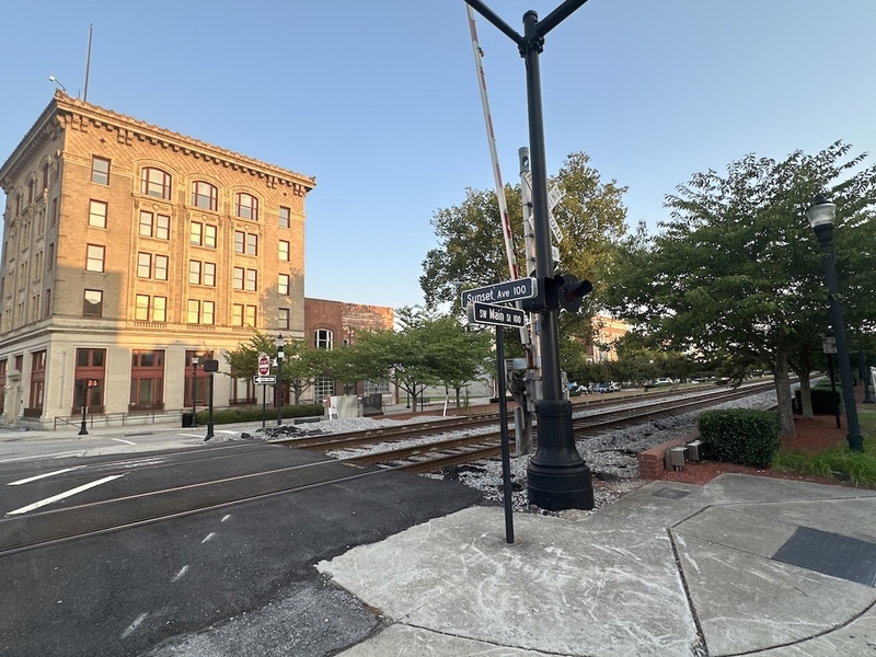 The setting sun’s glow reflects off a building near the intersection of SW Main Street and Sunset Avenue in Rocky Mount, N.C. The railroad tracks that run down the center of Main Street also serve as a dividing line between Nash and Edgecombe counties, and have historically split the city by race and class. (Kevin Hardy/Stateline)