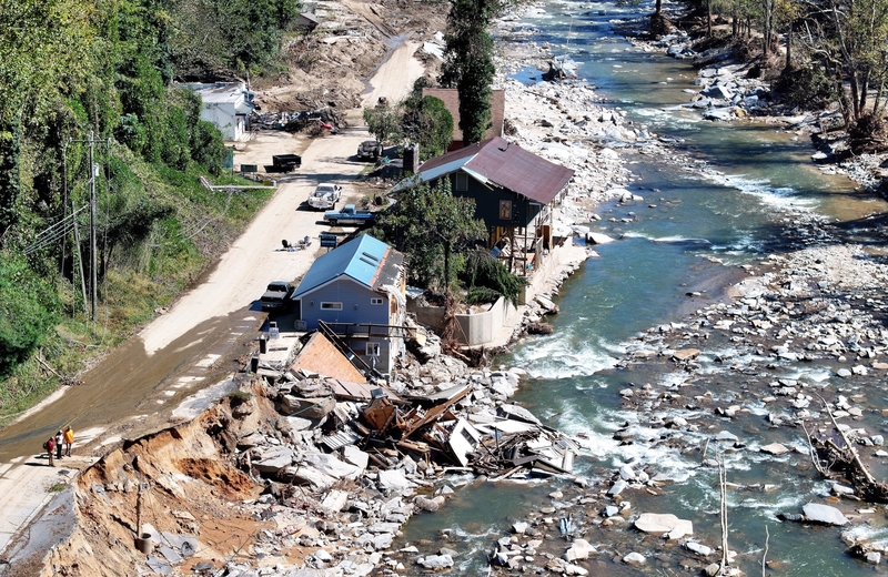 An aerial view of people standing near destroyed and damaged buildings in the aftermath of Hurricane Helene flooding on Oct. 8, 2024 in Bat Cave, North Carolina. (Photo by Mario Tama/Getty Images)